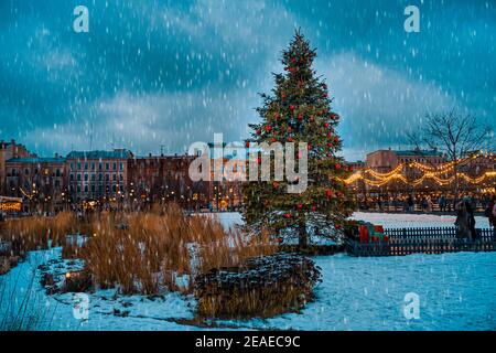 Ein geschmückter Weihnachtsbaum auf einem Stadtplatz. Über Nacht Schneefall. Neujahrskarte. Neujahrsurlaub in St. Petersburg Stockfoto