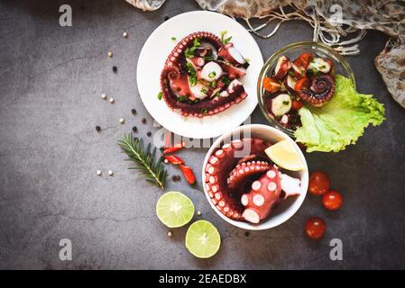 Octopus Salat Gemüse mit Zitronenlime Tomaten Chili Kräuter und Gewürz auf Teller und Schüssel, frischer und gesunder Salat Meeresfrüchte Tintenfisch und Tintenfisch Tentakeln Stockfoto