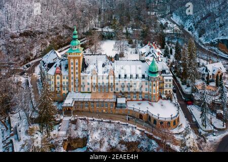 Lillafüred, Ungarn - Luftaufnahme des berühmten historischen Palastes, der von Schnee bedeckt ist, nahe dem See Hámori. Unglaubliches Winterpanorama. Stockfoto