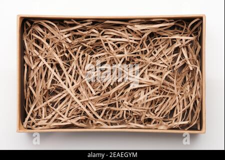 Offene braune Box mit geschreddertem Papier über Draufsicht isoliert Stockfoto