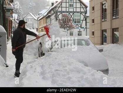 Wernigerode, Deutschland. Februar 2021, 08th. Ein Autofahrer schaufelt sein geparktes Fahrzeug vom Straßenrand ab. Quelle: Matthias Bein/dpa-Zentralbild/dpa/Alamy Live News Quelle: dpa picture Alliance/Alamy Live News Stockfoto