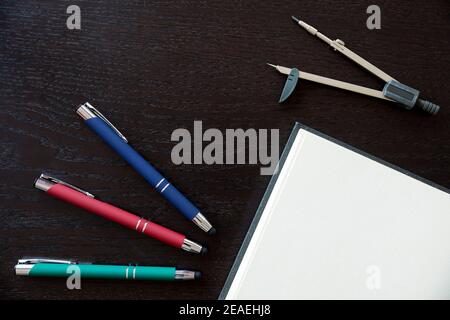 Stifte, Notizbuch und Zeichenkompass, um mit dem Logo Ihres Unternehmens zu personalisieren Stockfoto