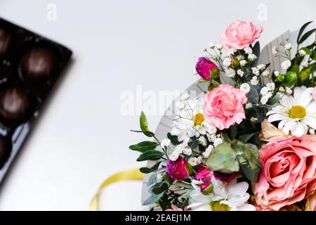 Blumen und Schokolade. Blumen, Brautstrauß Nahaufnahme. Dekoration von Rosen, Pfingstrosen und Zierpflanzen, Nahaufnahme, niemand, Objekte. Geschenk für Stockfoto