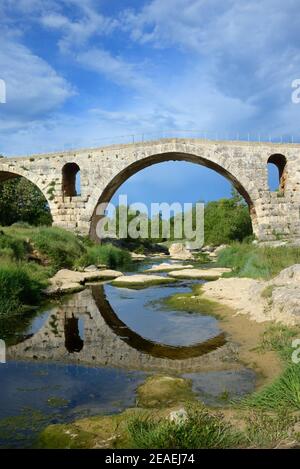 Bogen der römischen Brücke Pont Julien (3BC), auf der Via Domitia Römische Straße, spiegelt sich in der Calavon Bonnieux Luberon Provence Frankreich Stockfoto