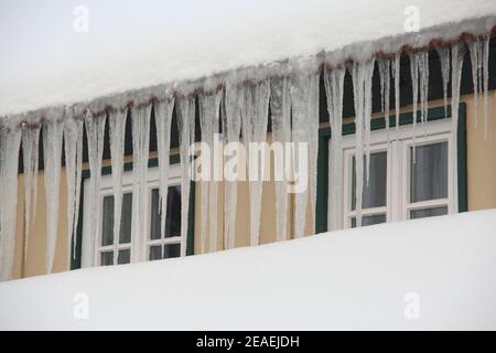 Wernigerode, Deutschland. Februar 2021, 08th. Eiszapfen hängen vor den Fenstern eines Mehrfamilienhauses. Quelle: Matthias Bein/dpa-Zentralbild/dpa/Alamy Live News Quelle: dpa picture Alliance/Alamy Live News Stockfoto