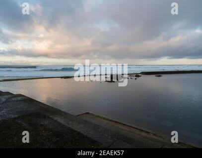 Natürliches Meerschwimmbad Los Charcones de Banaderos mit Wellen des atlantischen Ozeans bei Sonnenuntergang, Gran Canaria, Kanarische Inseln, Spanien Stockfoto