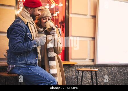 Fröhliches junges Paar mit Kaffee auf der Straße Stockfoto