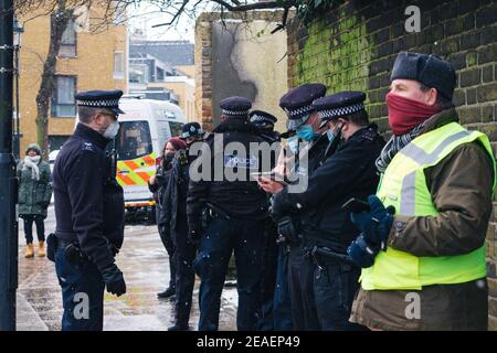 London, Großbritannien. Februar 2021, 9th. Highbury Corner Räumung, eine Reihe von Polizisten stehen im Schnee, nicht sehr sozial distanziert. Highbury, London, Großbritannien 9th. Februar 2021. Kredit: Denise Laura Baker/Alamy Live Nachrichten Stockfoto