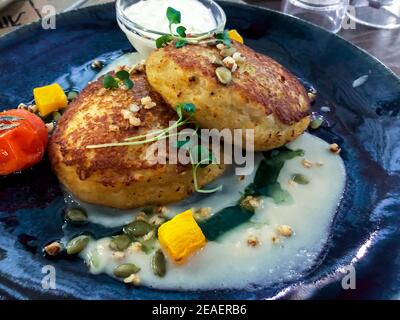 Kartoffelpfannkuchen gefüllt mit Fleisch, Sauerrahm, Gemüsesauce. Studio Foto Stockfoto