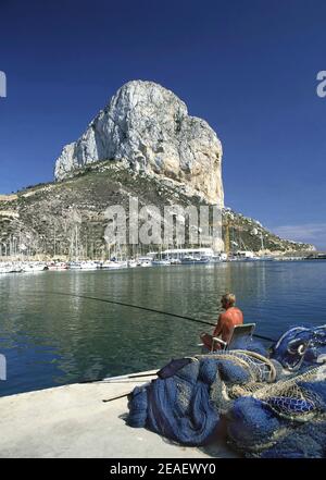 Fischer Angelrute & ikonischen natürlichen Kalkstein Wahrzeichen steigt aus Mittelmeerküste erhielt Naturparkstatus 1987 Calpe Alicante Spanien Stockfoto