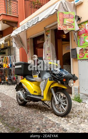 Piaggio Liberty Roller in der Poste Italiane S.p.A. Lackierung vor einem Geschäft in Malcesine, Gardasee, Italien geparkt. Stockfoto