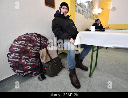 Erfurt, Deutschland. Februar 2021, 09th. Dennis Andreas Voigt, ein Obdachloser, sitzt im Speisesaal des Erfurter Caritas Tagestreff. Der Treffpunkt ist zwischen 9 und 4 Uhr geöffnet. Obdachlose können in der Suppenküche eine warme Mahlzeit einnehmen und sich mit einer Tasse Kaffee oder Tee aufwärmen. Quelle: Martin Schutt/dpa-Zentralbild/dpa/Alamy Live News Stockfoto