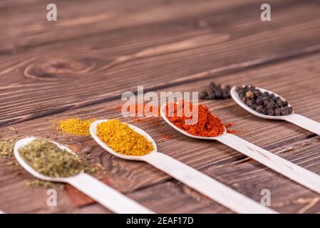 Auswahl an bunten Gewürzen in den Kochlöffel. Stockfoto