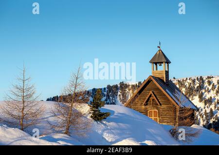 Alpine Holzkirche am Passo Valles, Wintersaison. Sonnenlicht im Morgengrauen. Die Dolomiten. Italienische Alpen. Europa. Stockfoto