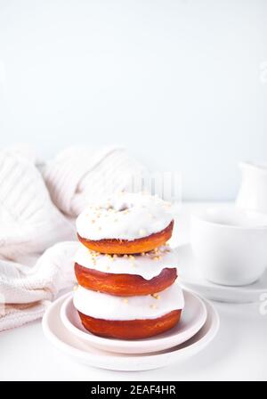 Donuts auf dem Teller glasiert weiße Schokoladencreme oder Glasur Und Flasche mit Milch auf dem Hintergrund Stockfoto