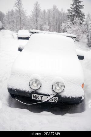 Auto in einer norwegischen Straße von einer Schneedecke bedeckt Stockfoto