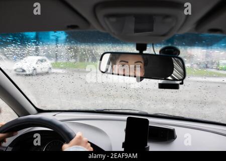 Der Taxifahrer schaut auf den Passagier und kommuniziert mit dem Kunden Stockfoto