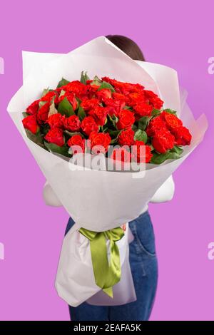 Das Mädchen mit großem Strauß roter Blumenrosen Stockfoto