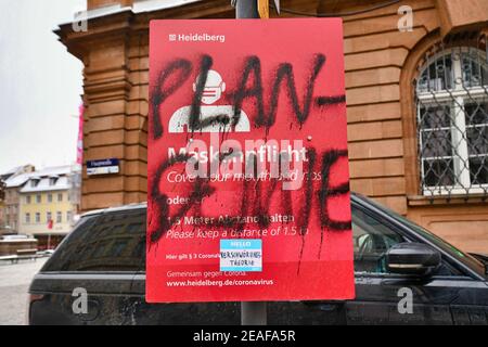 Heidelberg, Deutschland - Februar 2021: Wort 'Plandemic' auf Deutsch geschrieben über Zeichen für Gesichtsmaske und Abstand Anforderung von Verschwörungstheoretiker in p Stockfoto