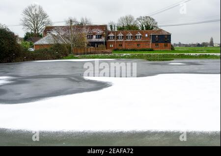 Dorney, Buckinghamshire, Großbritannien. 9th. Februar 2021. Nach den jüngsten Überschwemmungen aufgrund des hohen Grundwasserspiegels sind Seen im Dorney Common entstanden. Diese sind nun zugefroren und wurden heute Nachmittag von einem leichten Schneegestäuber bedeckt. Die Temperaturen später in dieser Woche werden voraussichtlich die kältesten seit 10 Jahren sein. Quelle: Maureen McLean/Alamy Live News Stockfoto