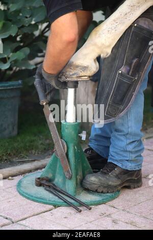 Unbekannter Schmied, der im Sommer mit einem Hufeisen im Freien arbeitet Stockfoto