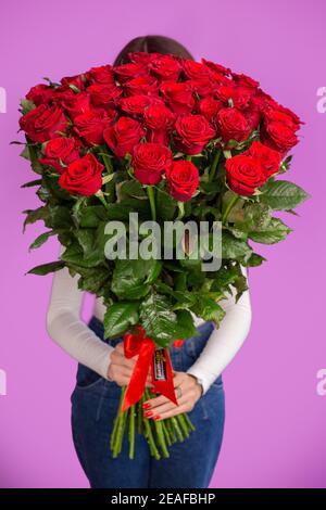 Das Mädchen mit einem großen Strauß roter Rosen Stockfoto