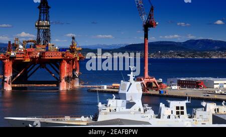 AGOTNES, NORWEGEN - 24. JULI 2020: Wartung der Offshore-Bohranlage in Agotnes bei Bergen, Norwegen. Im Vordergrund: HNoMS Helge Ingstad Navy Fregatte wai Stockfoto