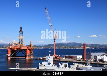 AGOTNES, NORWEGEN - 24. JULI 2020: Wartung der Offshore-Bohranlage in Agotnes bei Bergen, Norwegen. Im Vordergrund: HNoMS Helge Ingstad Navy Fregatte wai Stockfoto