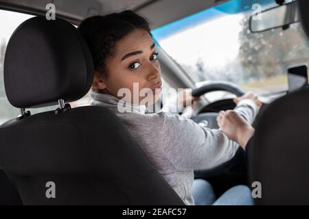 Elegante Frau Fahrer schaut auf den Rücksitz, fragen Beifahrer zu legen Sicherheitsgurt Stockfoto
