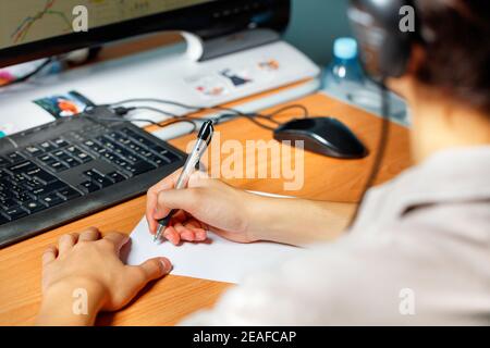 Online-Lernkonzept, sitzt ein junger Mann vor einem Computer-Monitor und bereitet sich auf einen Vortrag skizzieren. Stockfoto