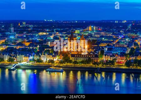 Nachtansicht der Uferpromenade und der St. Martin Kirche in Köln, Deutschland Stockfoto