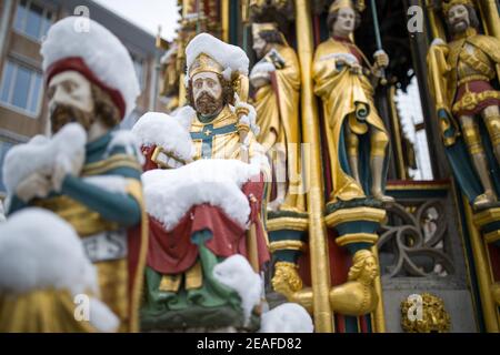 Nürnberg, Deutschland. Februar 2021, 09th. Die Figuren auf dem "schönen Brunnen" auf dem Hauptmarkt in der Altstadt sind mit Schnee bedeckt. Die Figuren sollen die Weltanschauung des Heiligen Römischen Reiches im Mittelalter darstellen. Der schöne Brunnen wurde auf Wunsch von Kaiser Karl IV. Im letzten Jahrzehnt des 14th. Jahrhunderts erbaut. Quelle: Daniel Karmann/dpa/Alamy Live News Stockfoto