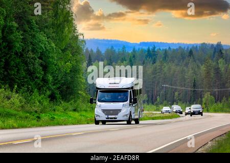 White Dethleffs Esprit Wohnmobil oder Wohnmobil unterwegs entlang der Autobahn in Mittelfinnland in der Dämmerung im Sommer. Jyväskylä, Finnland. Juni 7, 2019. Stockfoto