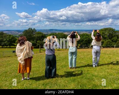 Gruppe von vier weiblichen Touristen mit Handys zu fotografieren Die englische Landschaft in den Cotswolds in der Nähe des Broadway Worcestershire England VEREINIGTES KÖNIGREICH Stockfoto