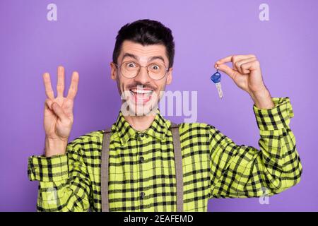 Foto Porträt von Kerl halten Tasten zeigt drei Finger isoliert Auf lebhaft violettem Hintergrund Stockfoto