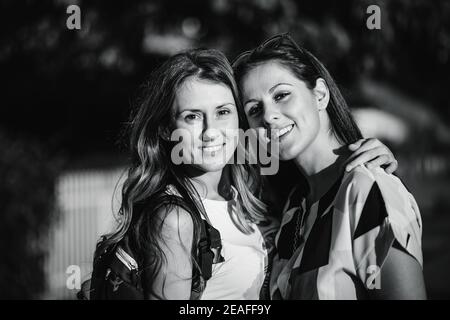 Schwarz-Weiß-Foto von zwei Schwestern umarmen und lächeln Stockfoto