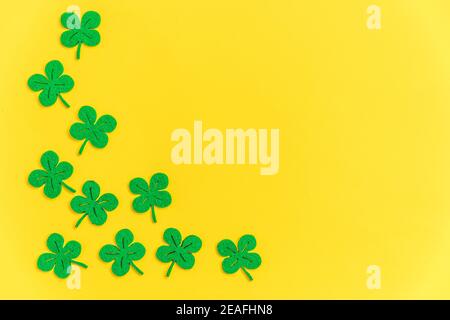 St. Patricks Day Hintergrund. Einfach minimalistisches Design mit grünem Kleeblatt. Kleeblätter isoliert auf gelbem Hintergrund. Symbol von Irland. Glück w Stockfoto