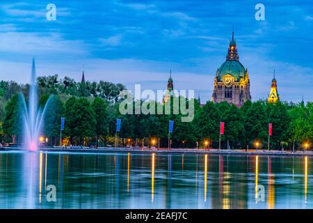 Sonnenuntergang Blick auf das neue Rathaus hinter dem Brunnen am Maschsee in Hannover, Deutschland Stockfoto