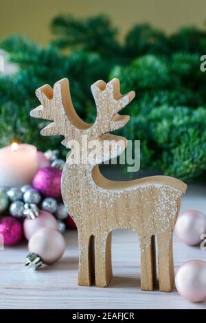 Hölzerne Hirschfigur auf dem Hintergrund von Tannenzweigen. Festliche Einrichtung Stockfoto