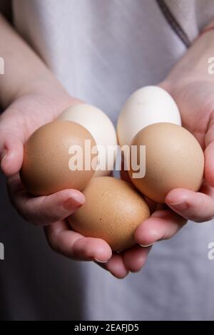 Hände einer unsichtbaren Person halten frische Hühnereier vom Bauernhof. Stockfoto