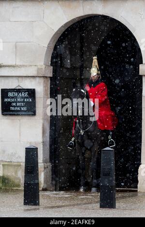 London, Großbritannien. 9. Februar 2021. UK Wetter: Ein Mitglied der Queen's Life Guard im Wachdienst vor der Horse Guards Parade während leichter Schneeverwehungen, da das kalte Wetter durch Sturm Darcy weiter anhält. Kredit: Stephen Chung / Alamy Live Nachrichten Stockfoto