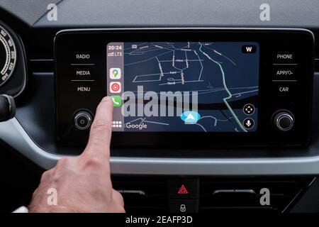 Nahaufnahme mans Hand Wählen Sie die Anwendung der Navigation oder Karten auf dem Auto Armaturenbrett. Januar 2021, Prag, Tschechische Republik. Stockfoto