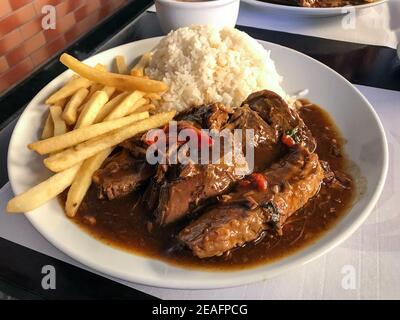 Rinderfilet Mignon mit Holzsoße mit Kartoffelchips und Reis Stockfoto