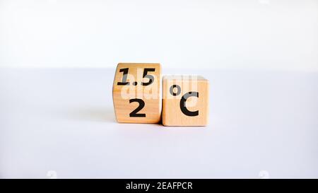 Symbol für die Begrenzung der globalen Erwärmung. Einen Würfel gedreht und den Ausdruck '2 C' in '1,5 C' geändert, oder umgekehrt. Konzept. Schöner weißer Tisch, weißer BA Stockfoto