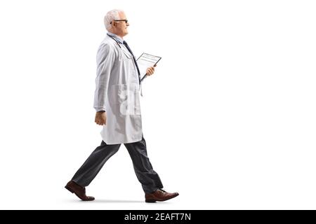 In voller Länge Profilaufnahme eines reifen Arztes, der isoliert geht Auf weißem Hintergrund Stockfoto