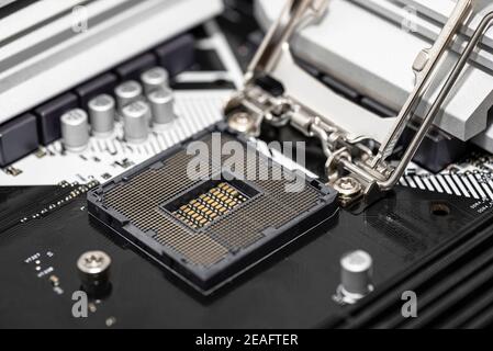 Makroaufnahme eines leeren modernen LGA 1200 Sockels für CPU auf schwarzem Desktop Motherboard. Stockfoto