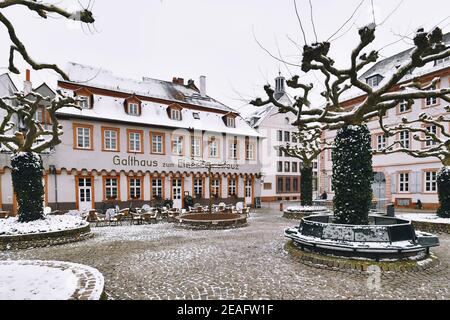 Heidelberg, Deutschland - Februar 2020: Karlsplatz mit leerem Restaurant und Schnee im Winter im historischen Stadtzentrum von Heidelberg Stockfoto