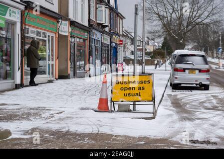 Unternehmen öffnen wie gewohnt Schild an Reihe von Geschäften in Southend on Sea, Essex, Großbritannien, mit Schnee von Storm Darcy. Die meisten geschlossen wegen COVID 19 Sperre. Eisig Stockfoto