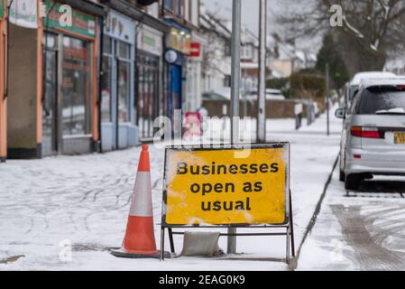 Unternehmen öffnen wie gewohnt Schild an Reihe von Geschäften in Southend on Sea, Essex, Großbritannien, mit Schnee von Storm Darcy. Die meisten geschlossen wegen COVID 19 Sperre. Eisig Stockfoto