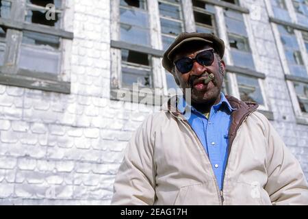 Porträt eines afroamerikanischen Mannes mittleren Alters, der ein Rauchen Zigarre Stockfoto